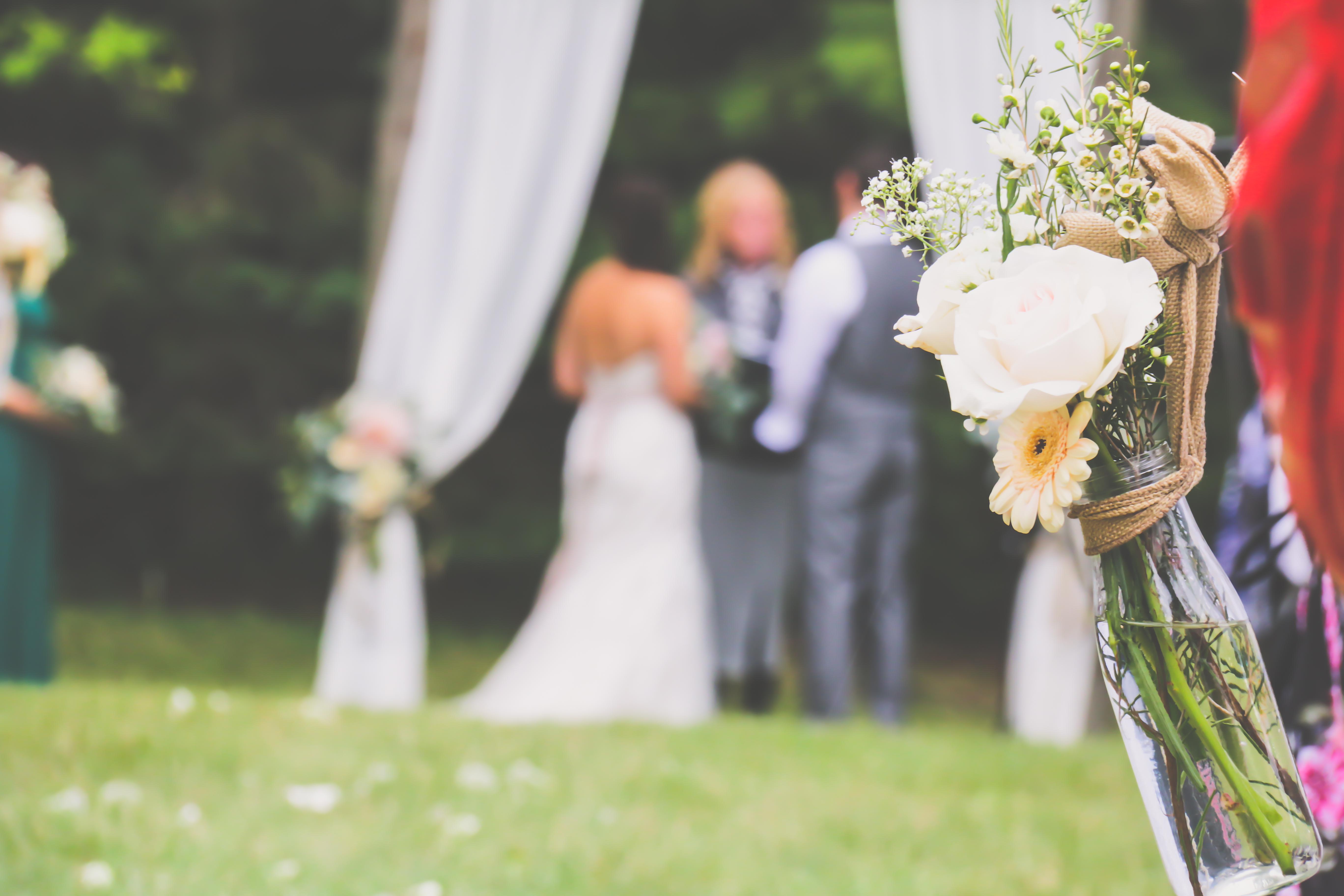 image of flowers with couple saying their vows in blurry background