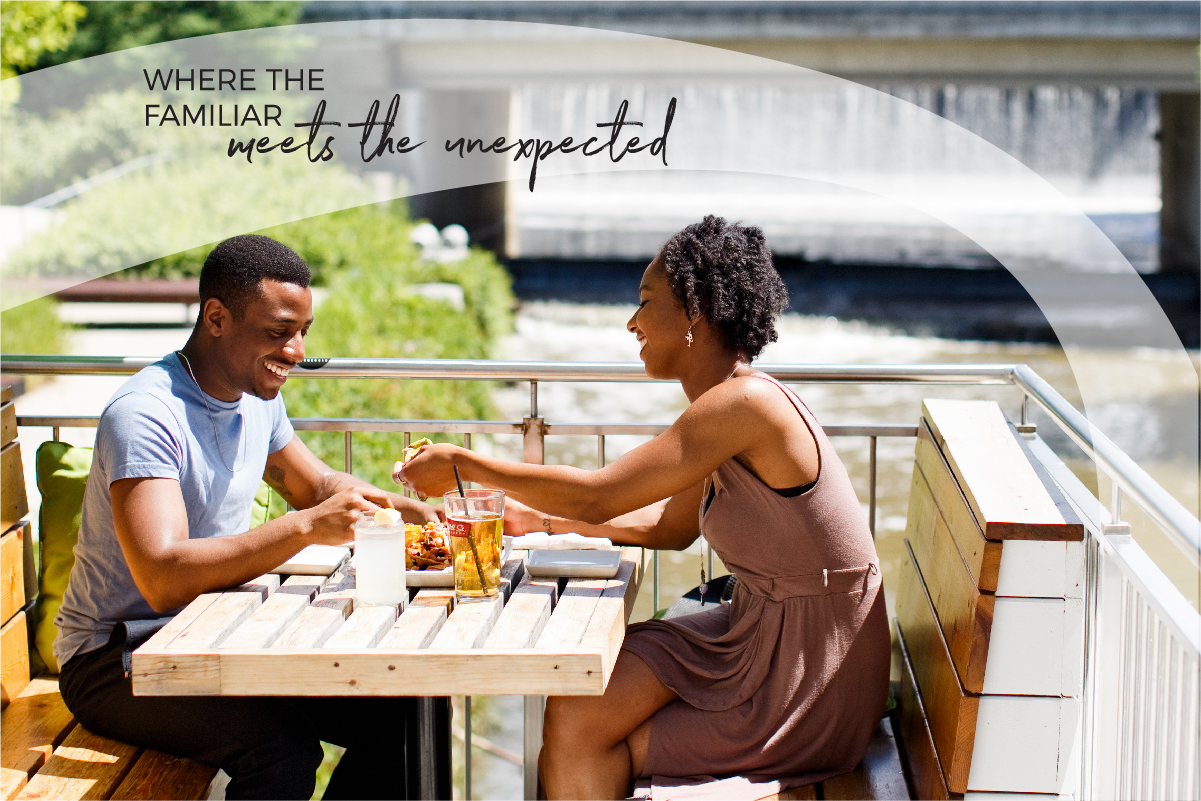 Two people sitting on a patio eating happily